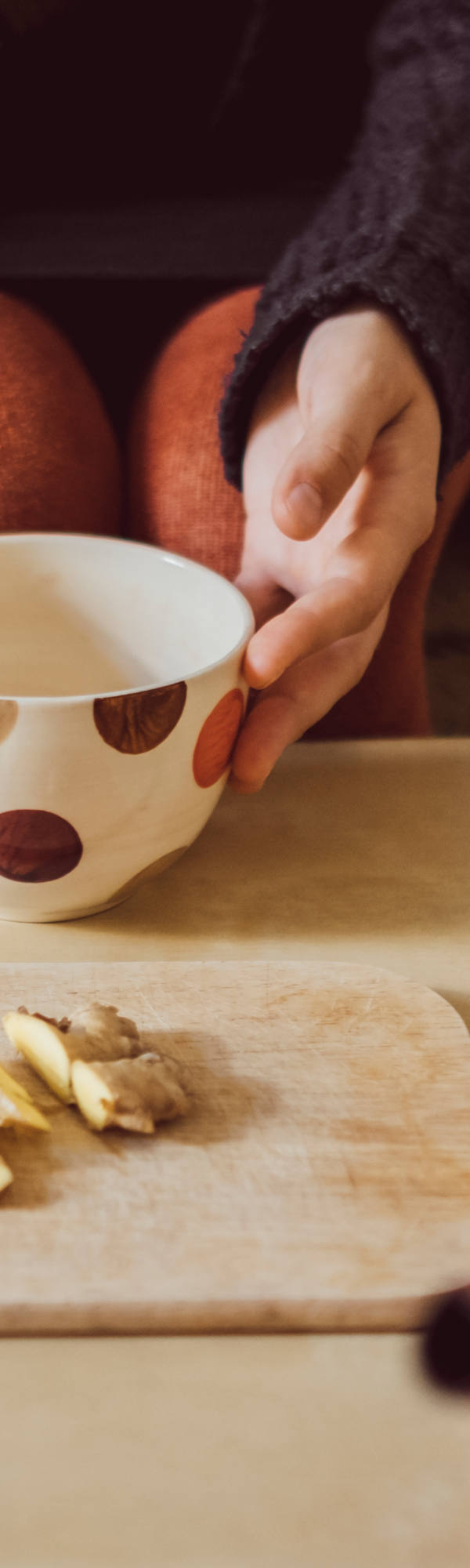 Woman prepares a ginger tea in the living room.
