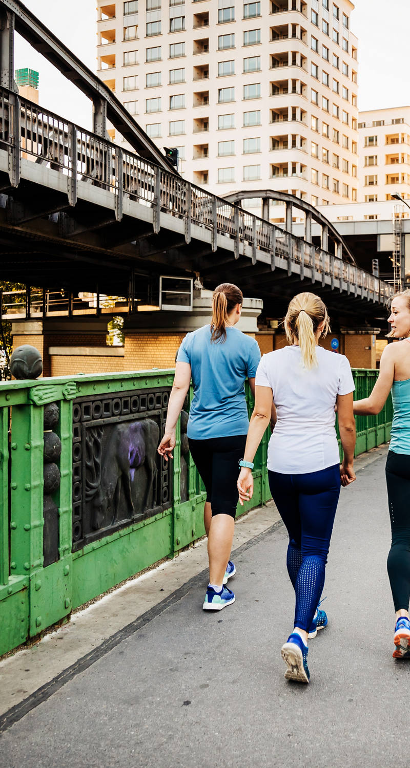 A group of women meets for jogging and runs through the city.
