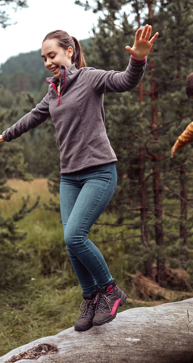  Adolescents en équilibre sur un tronc d’arbre dans la nature