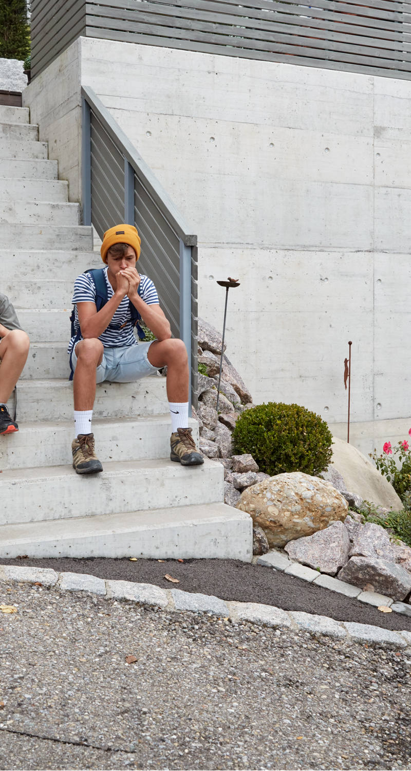 Two boys sitting on a staircase and waiting