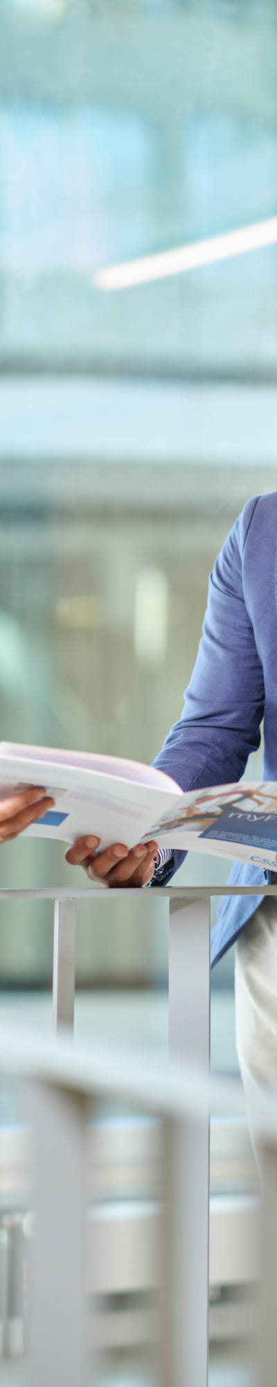A woman and a man are looking at a brochure in the corridor.
