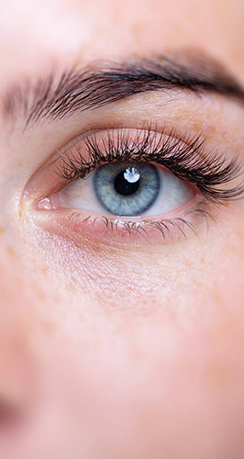 Eine Nahaufnahme einer Person mit blauen Augen, die in die Kamera schaut.