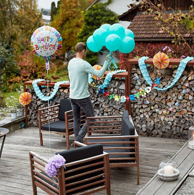 Mann dekoriert Terrasse für eine Geburtstag-Party