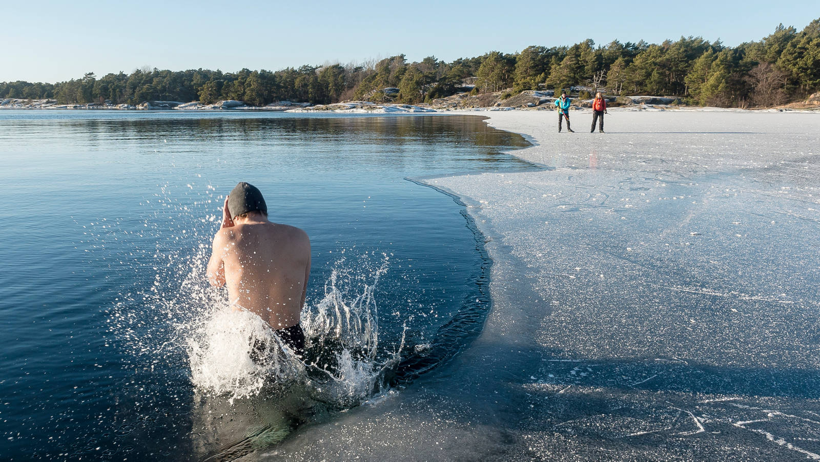 Mann nimmt während Winter im See ein Eisbad.