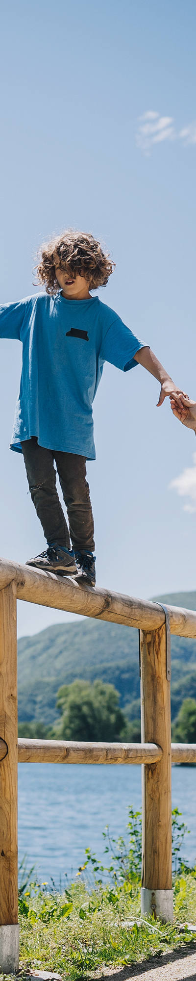 Garçon en équilibre sur une clôture avec l’aide de son père