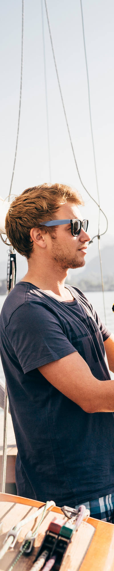 La famille profite d’une sortie en voile et le petit garçon s’émerveille en gilet de sauvetage jaune