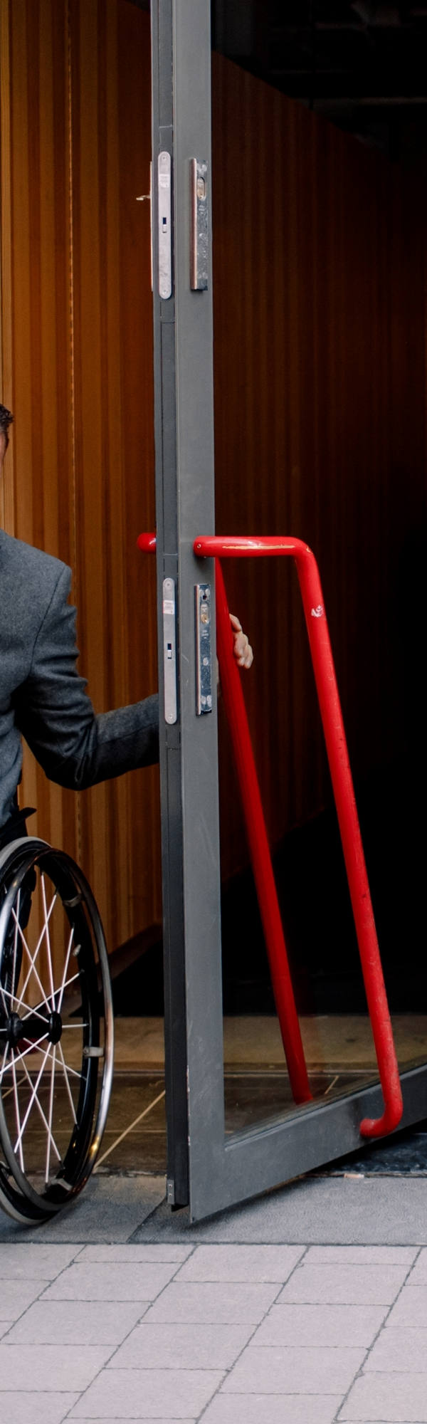  mieux écrire: Un homme en chaise roulante laisse un café par la porte.