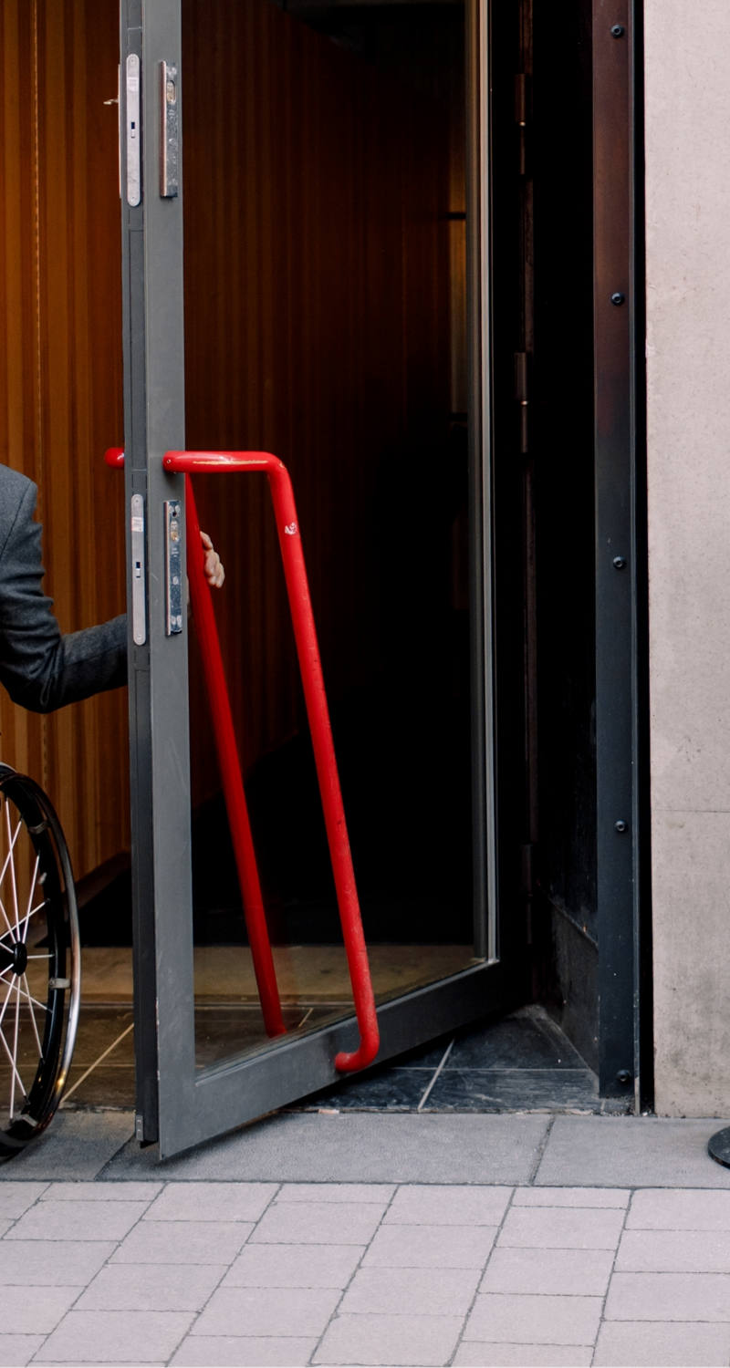  mieux écrire: Un homme en chaise roulante laisse un café par la porte.