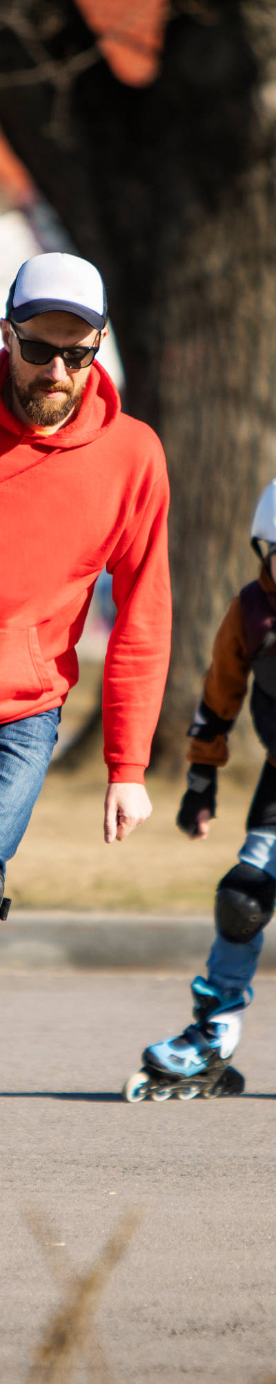 Père et fils font du roller dans un parc