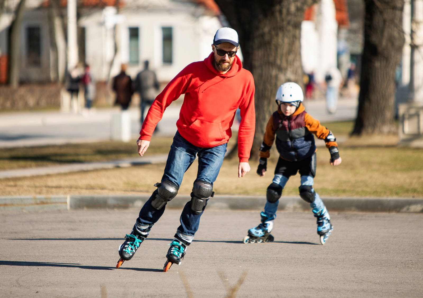 Father and son riding inline skates in a park