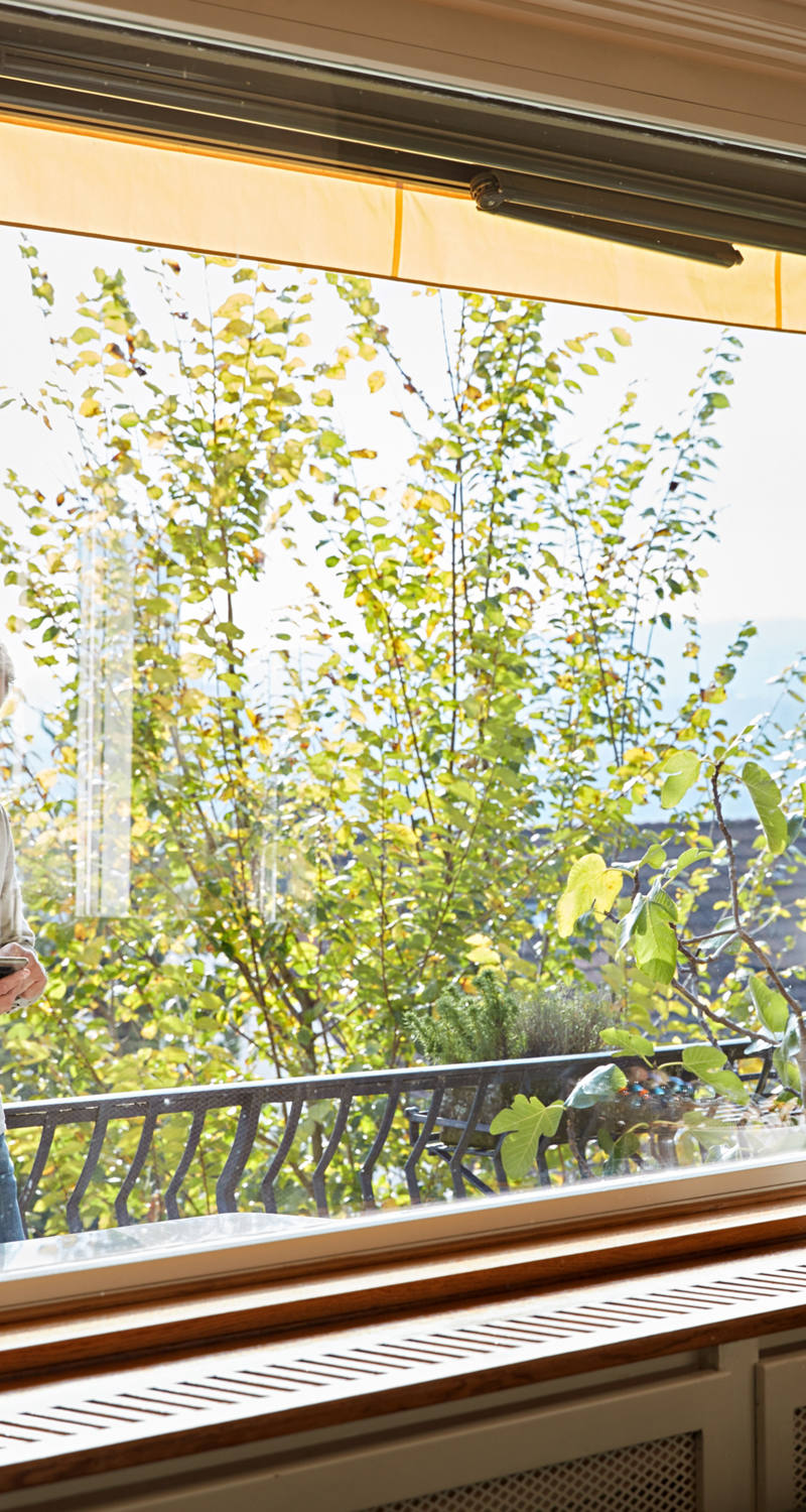 Uomo con smartphone sul balcone.