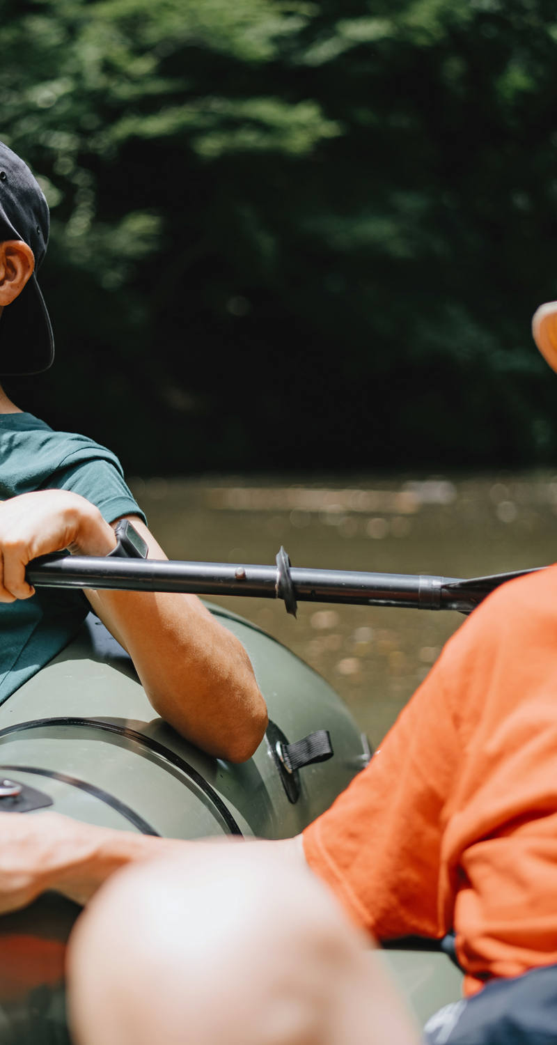 Jeune adulte est avec son père dans un bateau sur une rivière
