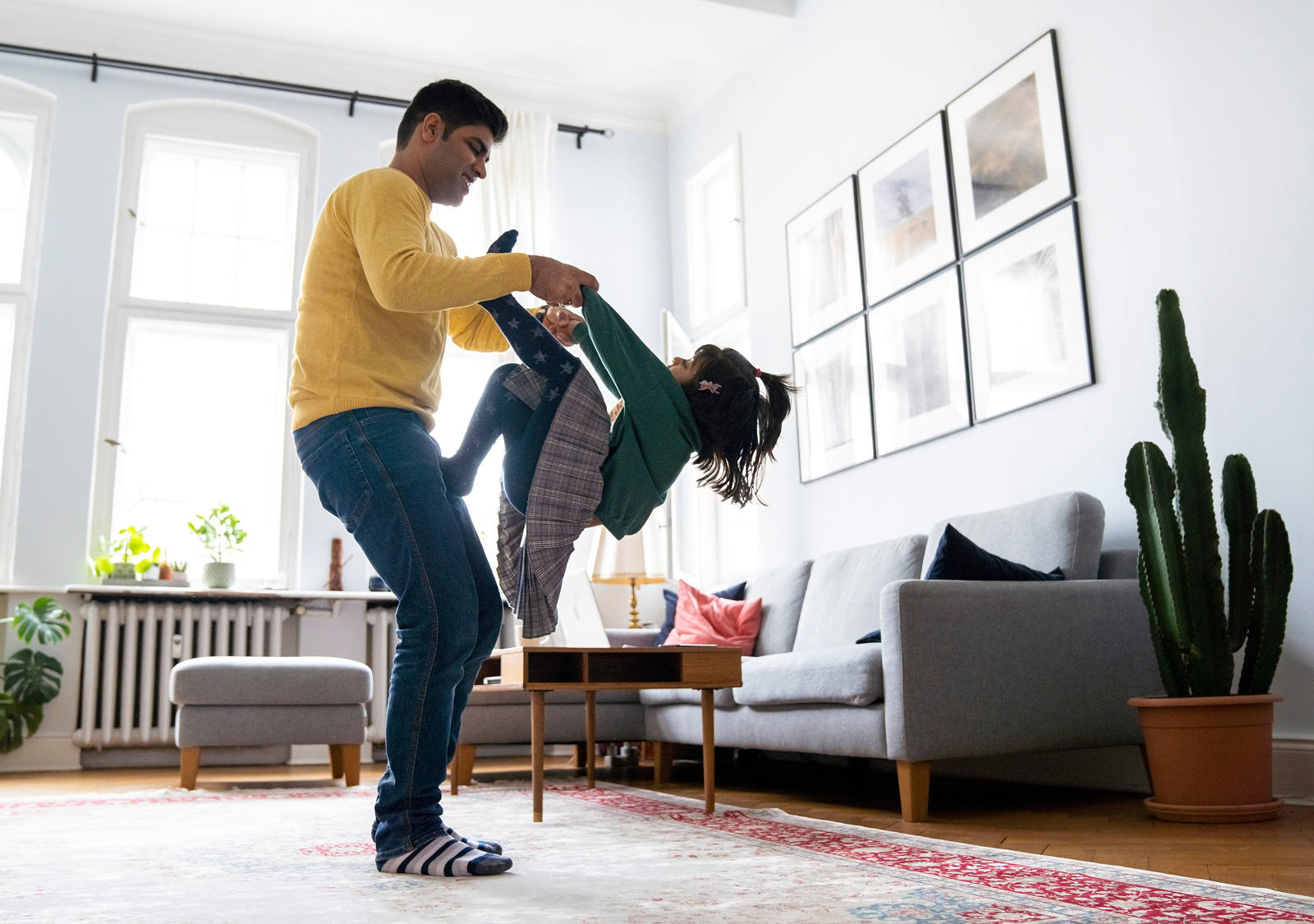 Vater spielt mit Tochter im Wohnzimmer