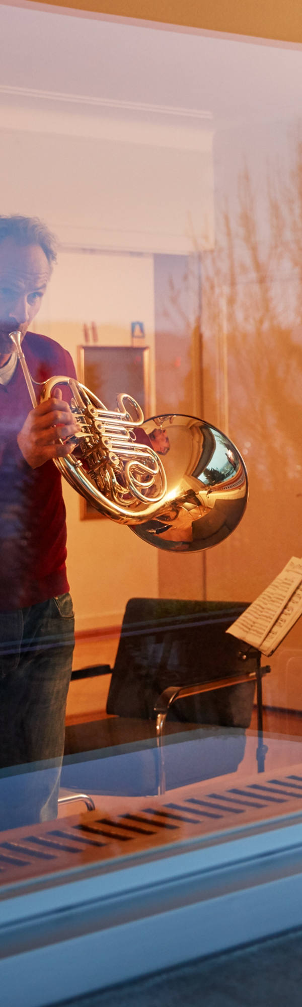 Uomo gioca nel suo salotto al crepuscolo Waldhorn