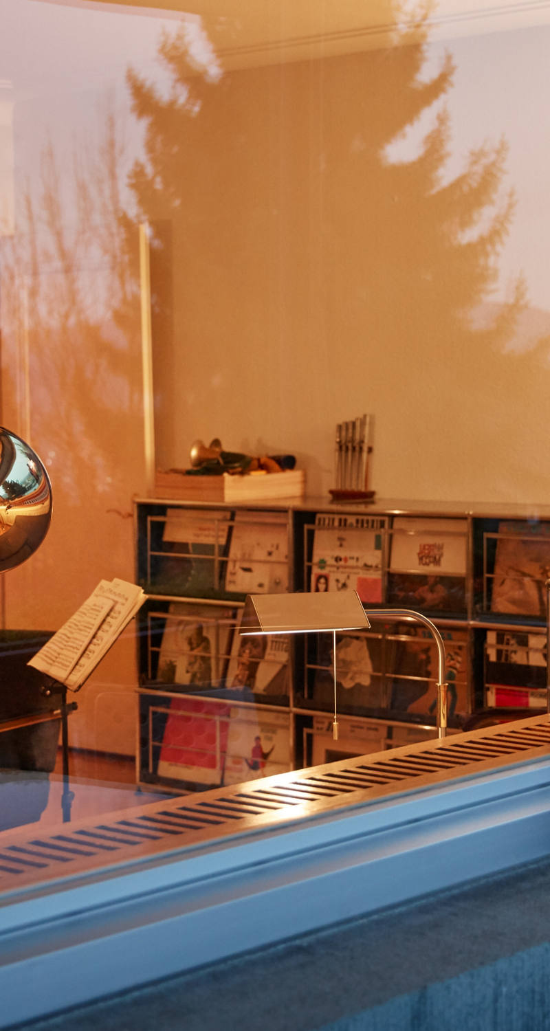 Man playing horn in his living room at dusk