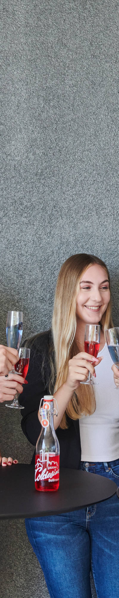 Eine Gruppe von Arbeitskollegen stossen auf der Terrasse bei einem Apéro an.