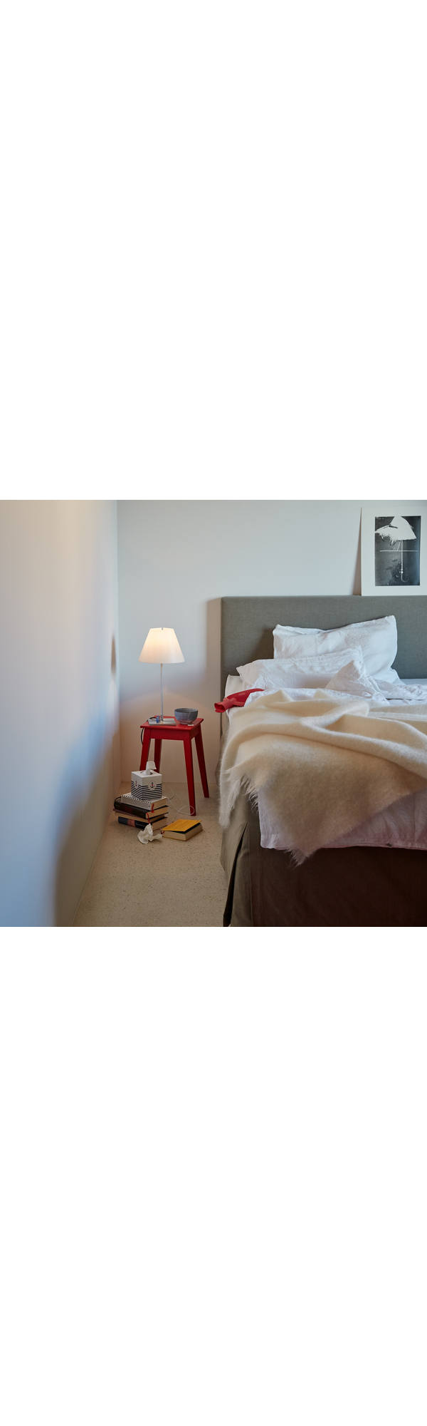 Une lampe de chevet allumée se tient à côté du lit.