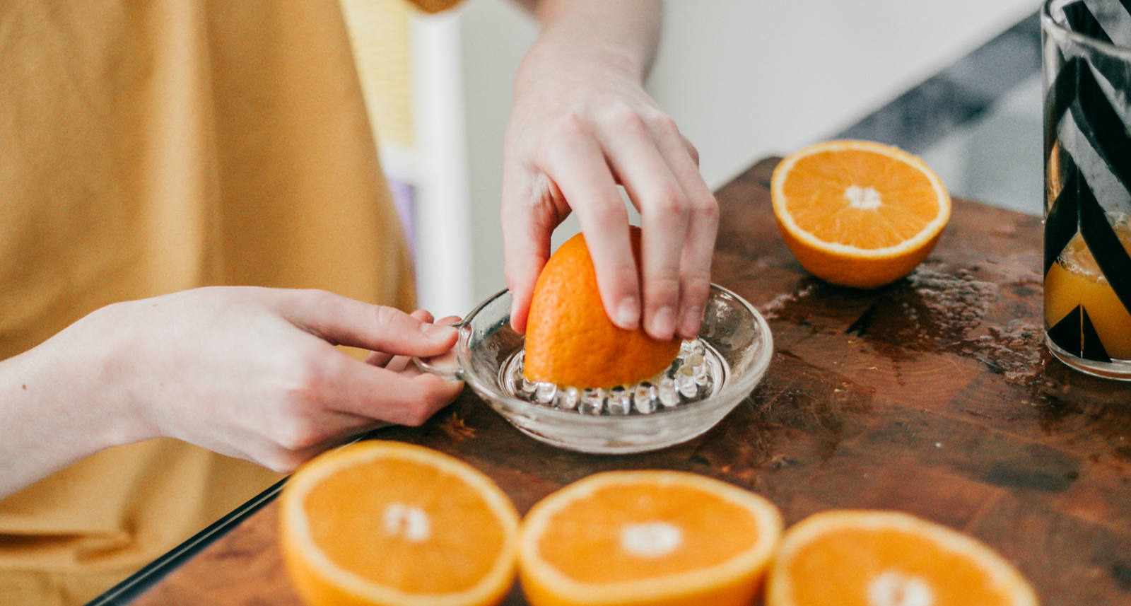 Femme presse des oranges fraîches en un jus d’orange