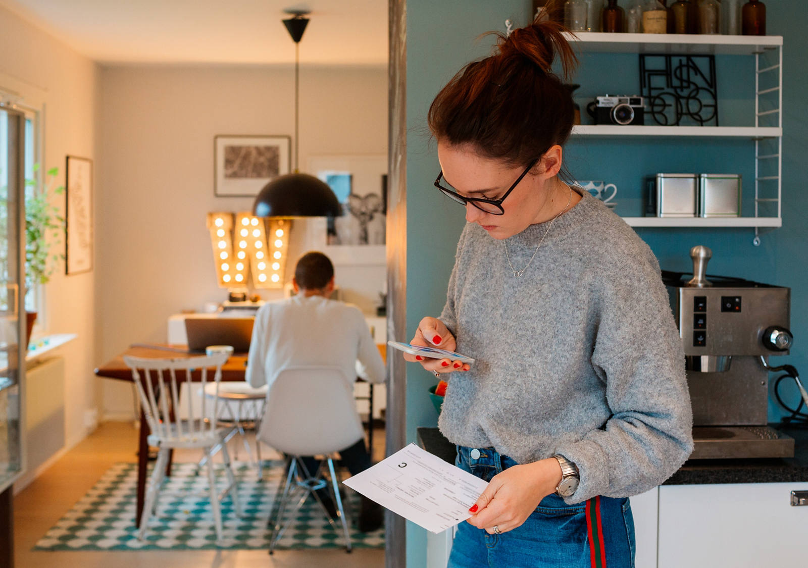 Frau scannt Einzahlungsschein mit Smartphone