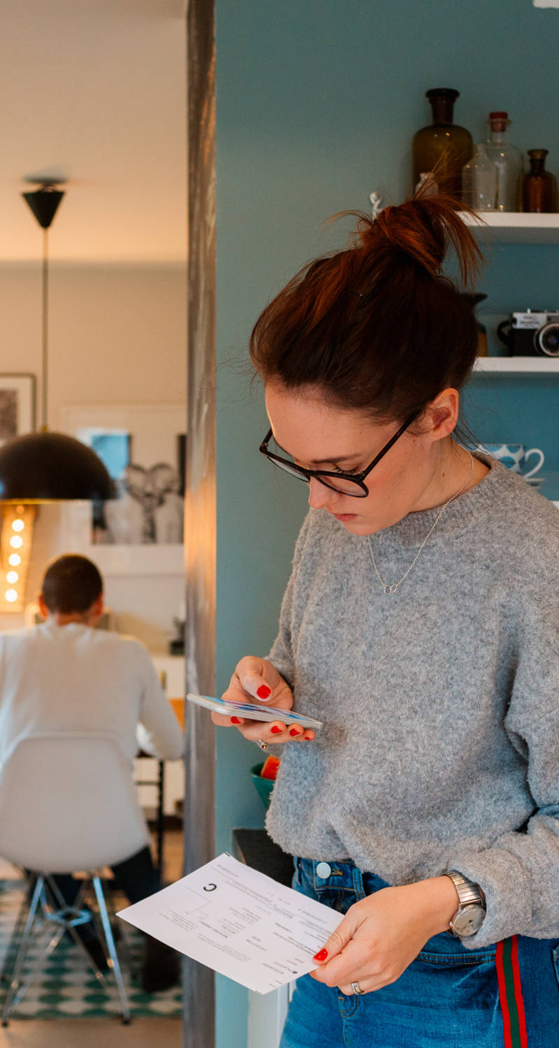 Frau scannt Einzahlungsschein mit Smartphone