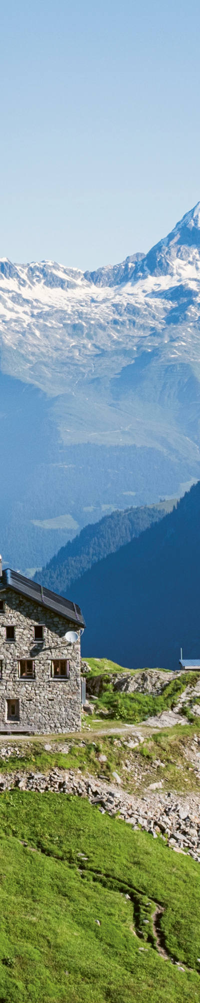 Cabane Terri du CAS située sur une colline herbeuse au cœur d’un paysage alpin.
