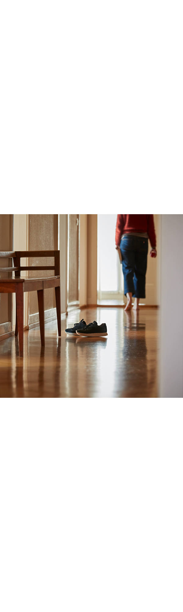 Frau läuft barfuss durch die Wohnung.