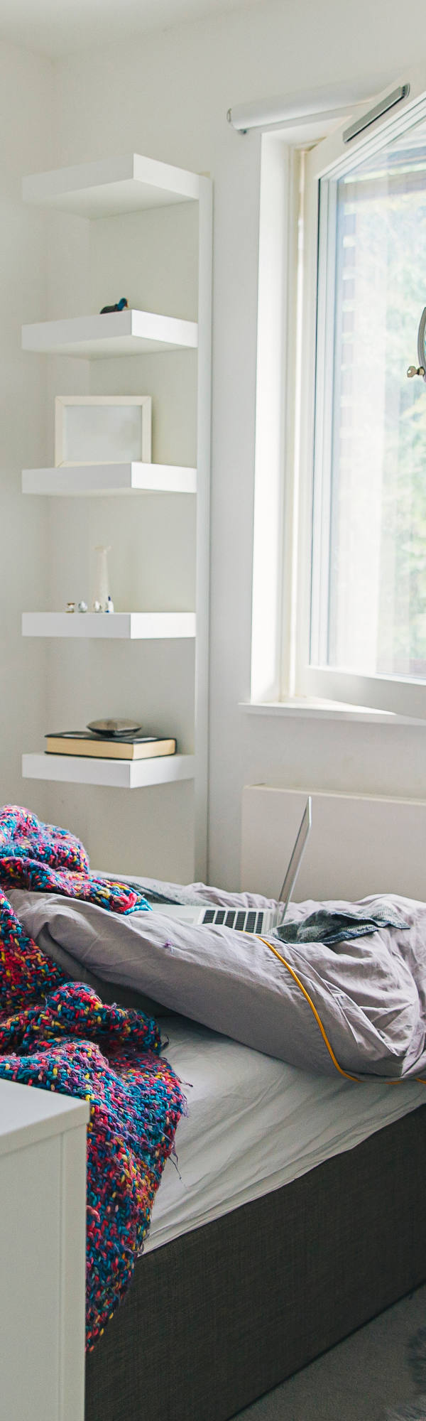 Una donna è a letto ammalata e guarda fuori dalla finestra.