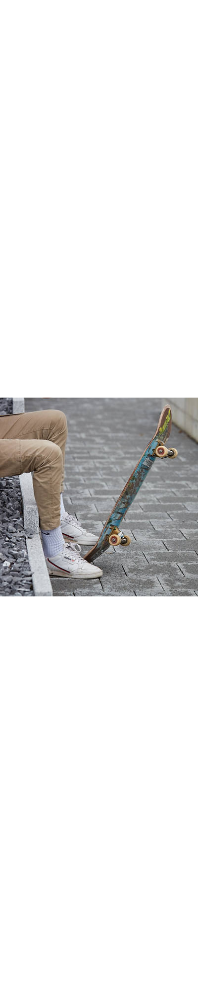 Junge flippt sein Skateboard hoch