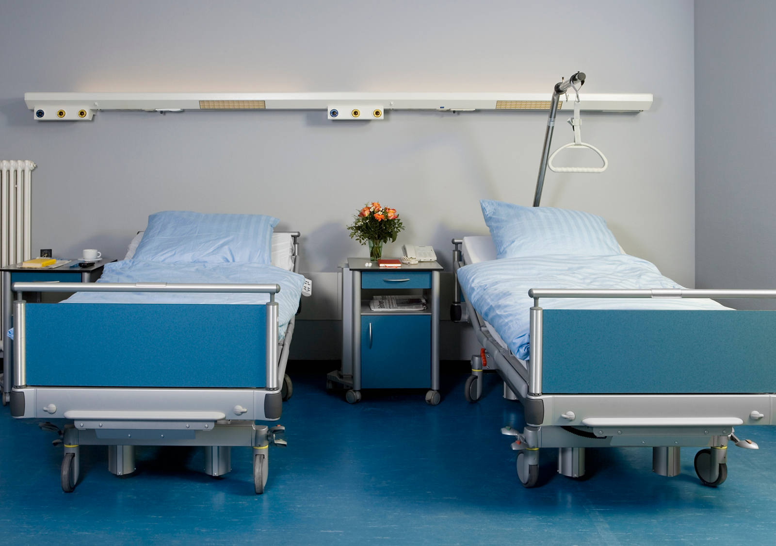 Two empty hospital beds in a hospital.