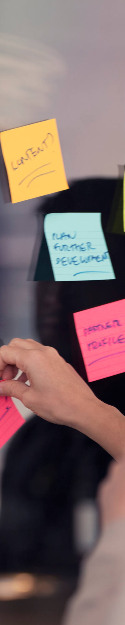 Une équipe colle des post-it sur un mur.