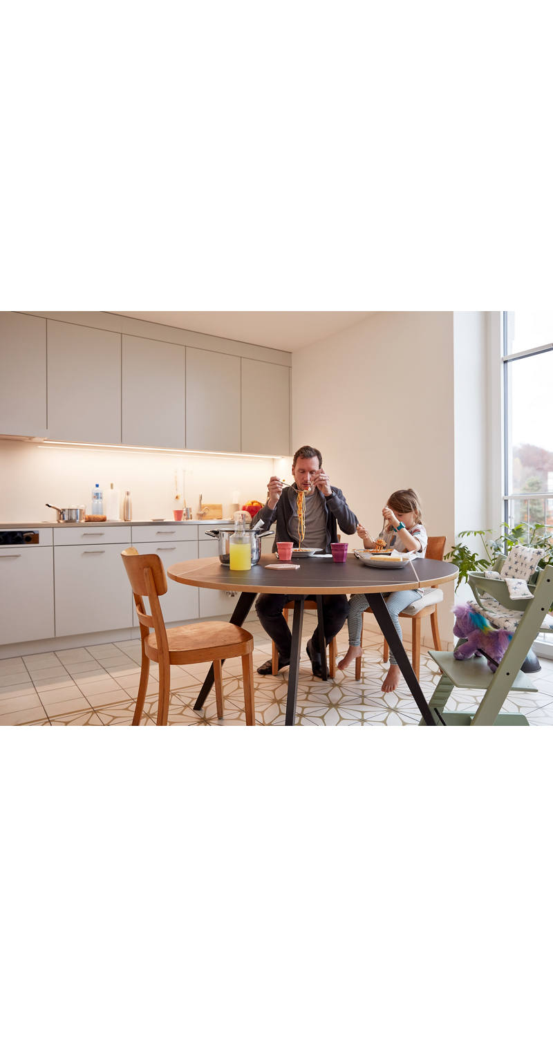 Père et fille mangent des spaghettis à la table de la cuisine