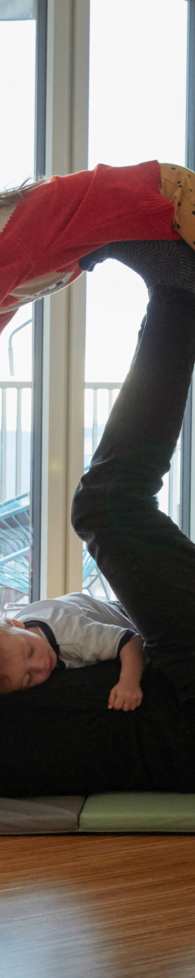 Father exercising with children in living room on the floor